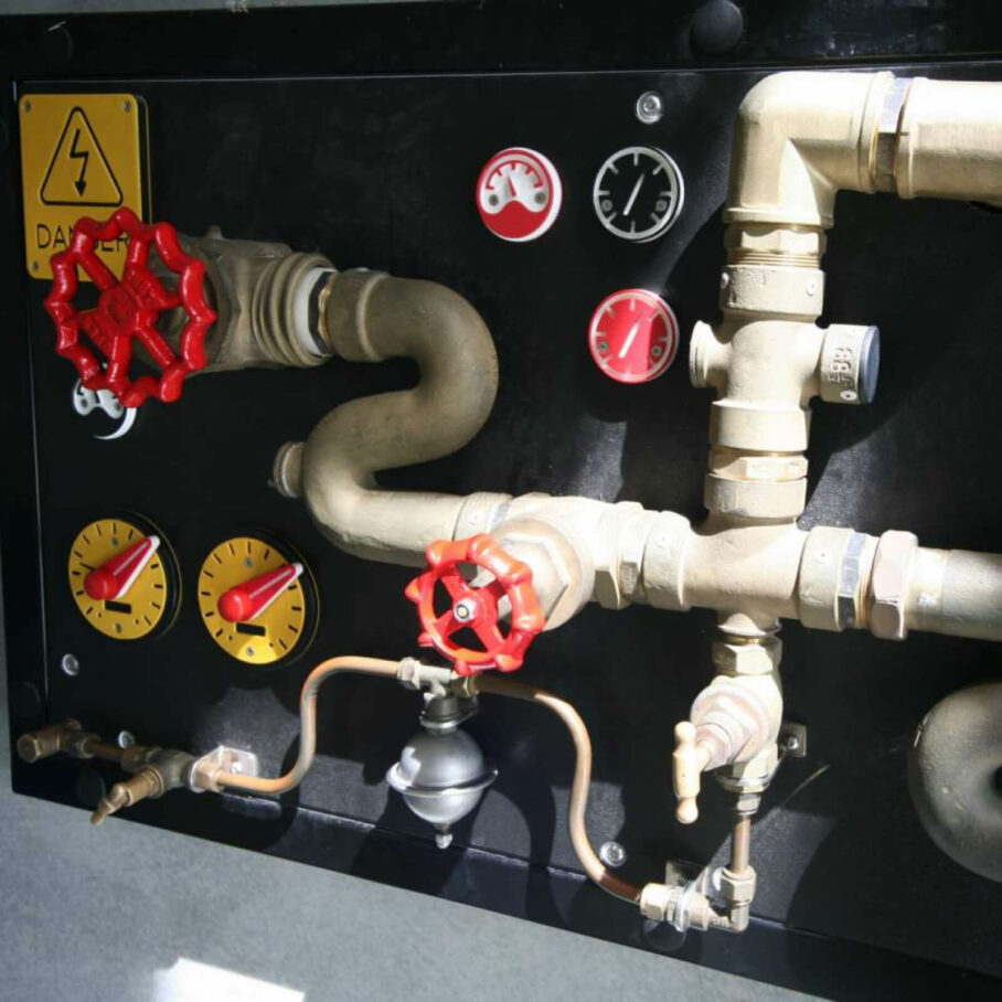 a wall of pipes and red gears